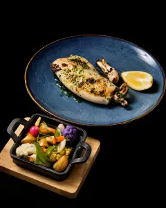 Calamar de potera a la brasa con guarnición de verduras, especialidad del restaurante Cal Miquel en Cala Pi