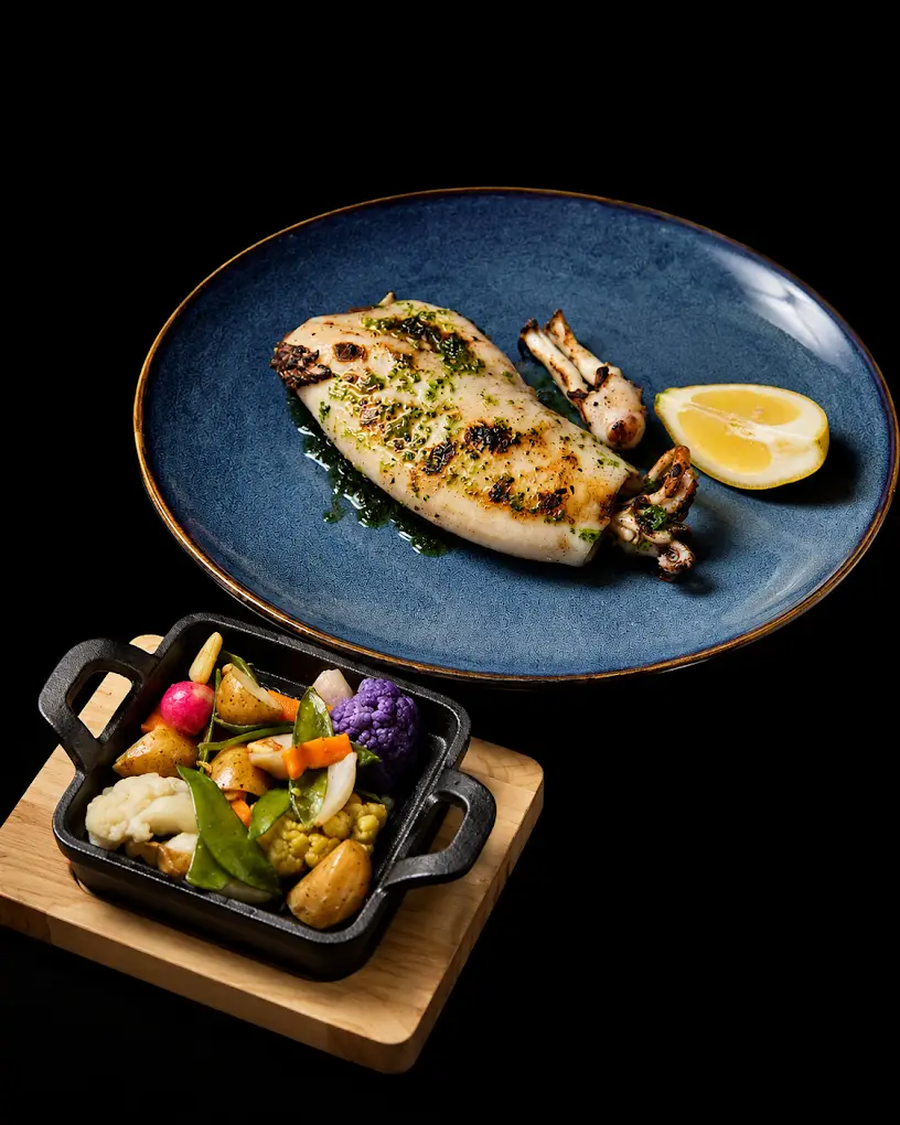 Calamar de potera a la brasa con guarnición de verduras, especialidad del restaurante Cal Miquel en Cala Pi