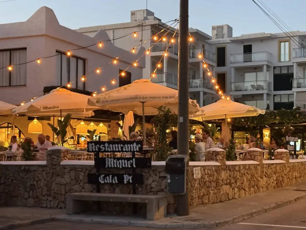 Terraza iluminada del restaurante Cal Miquel al atardecer en Cala Pi