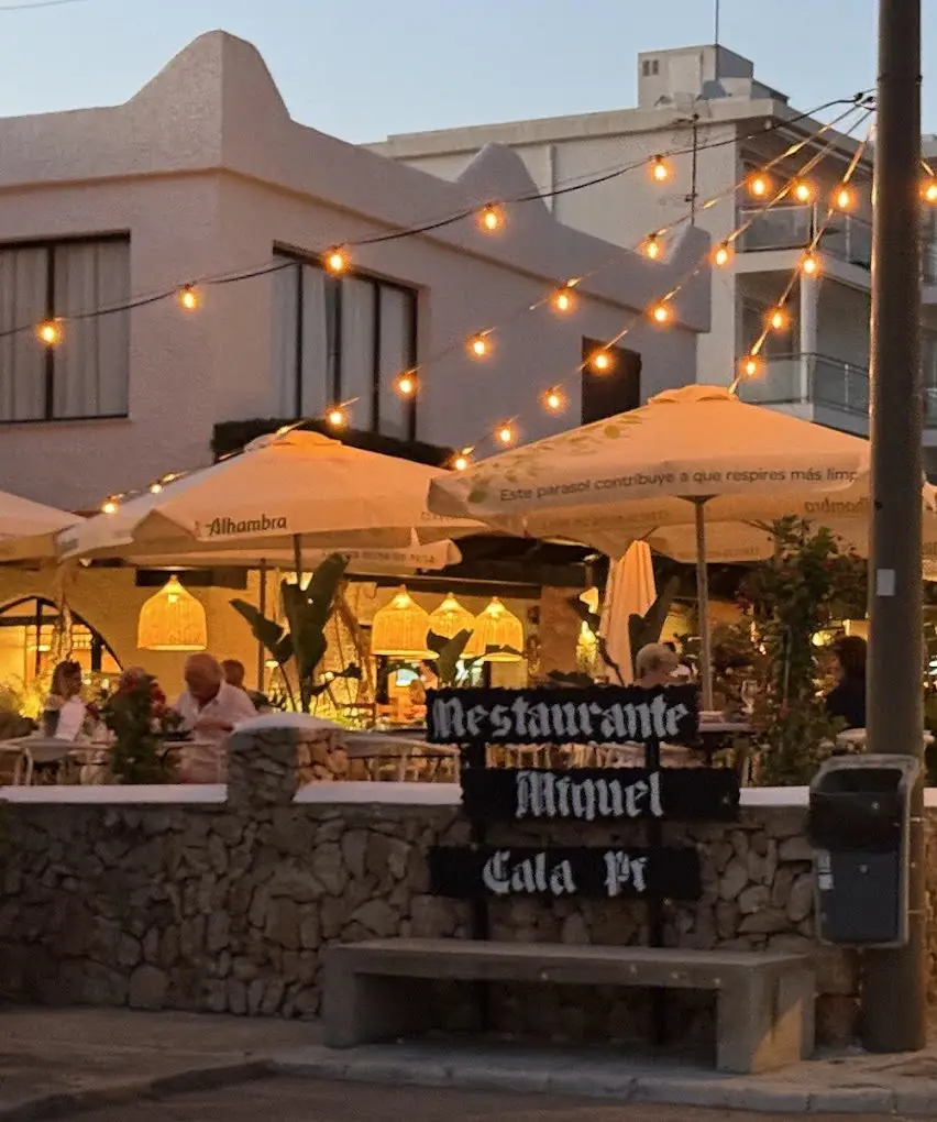 Terraza iluminada del restaurante Cal Miquel al atardecer en Cala Pi